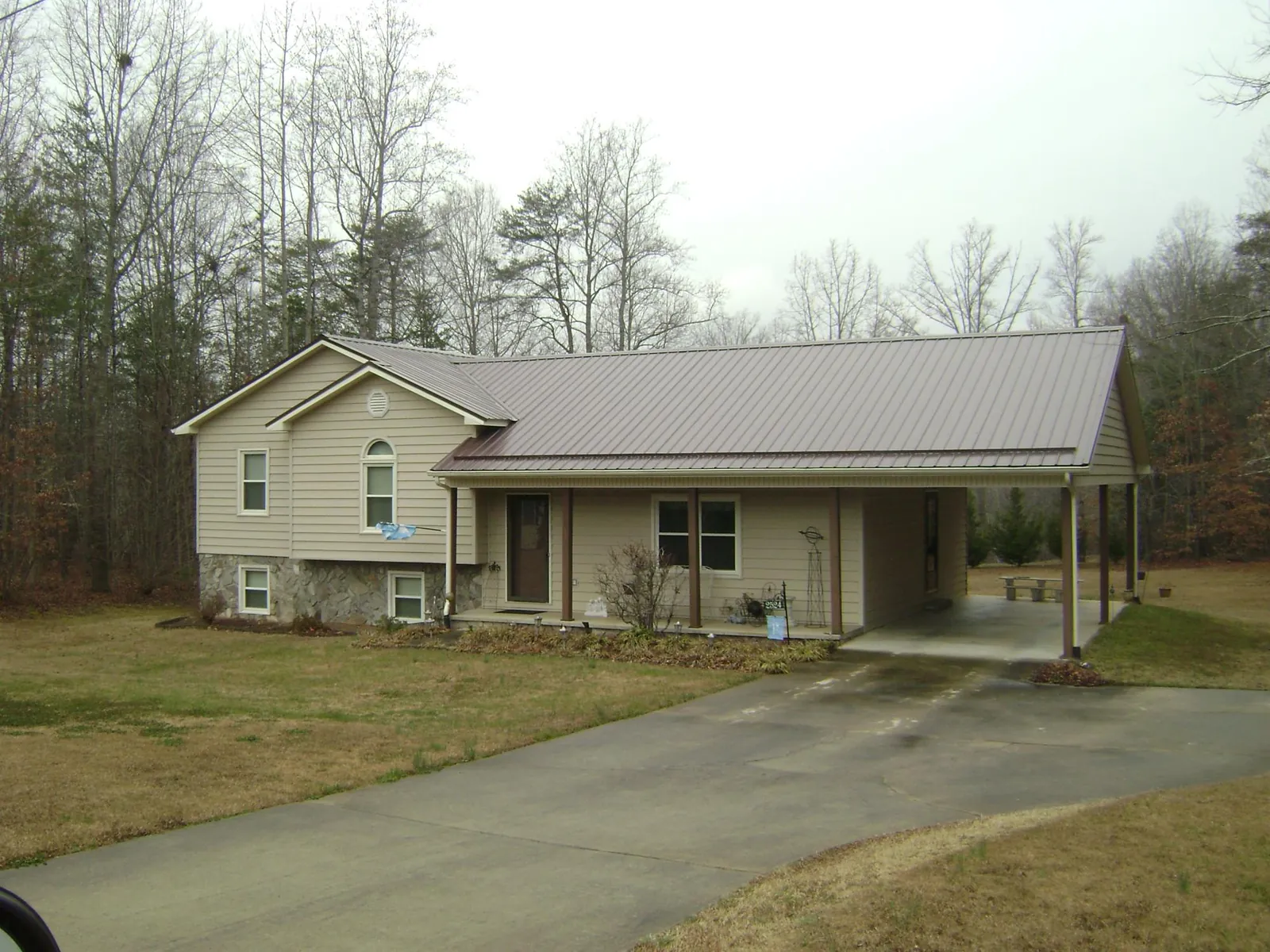 Brown metal roof on a tan split level home with an attached carport in Springfield